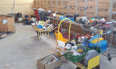 de nombreux cartons et chariots dans un entrepôt où des cartons sont posés à même le sol