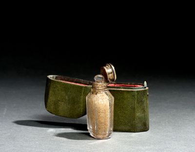 a small glass jar with a small bottle inside of it