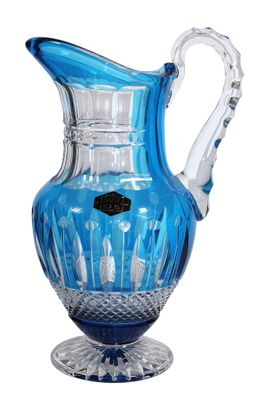 un pichet en verre bleu muni d'une anse et posé sur un socle