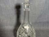une image représentant une carafe en verre sur fond gris