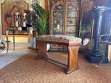 a wooden bench in a living room with a plant on it