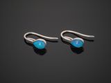 a pair of oplite earrings on a black surface