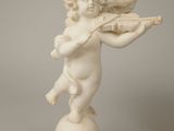 statue of cupid playing the violin on top of a ball