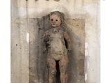 a small statue of a child that is in the corner of a wall