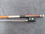 a close up of a violin bow and bow rest on a table