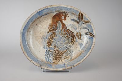 une assiette bleue et blanche sur laquelle est représenté un coq