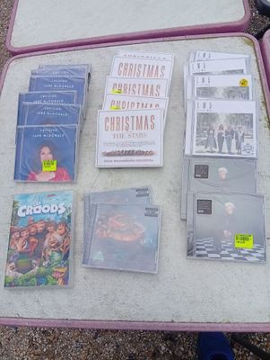 a pink suitcase with various movies and cds on it