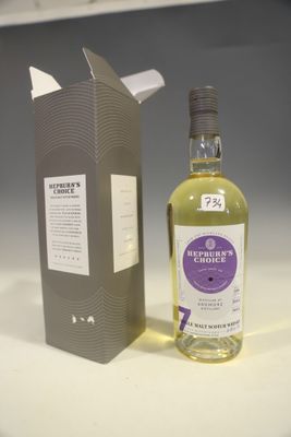 the bottle is next to the box on the table
