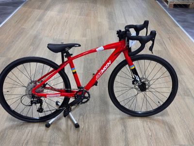 a red bike that is sitting on a wooden floor