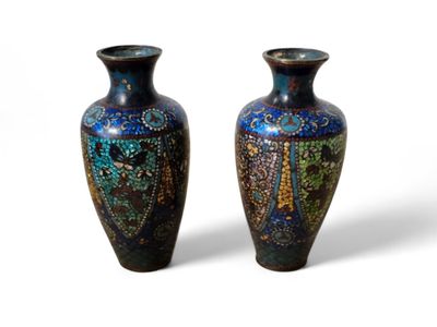 une paire de vases bleus et verts posés sur une surface blanche
