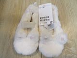 a pair of white slippers on a wooden floor
