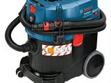 un aspirateur bleu et noir muni d'un tuyau, sur fond blanc