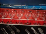 several empty wine glasses and spoons in a box on a table