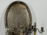 un plateau en argent avec trois bougies et un miroir