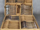 une boîte en bois remplie de nombreuses fourchettes et cuillères