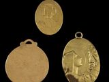 three gold medals with a woman ' s face and a man ' s face on them