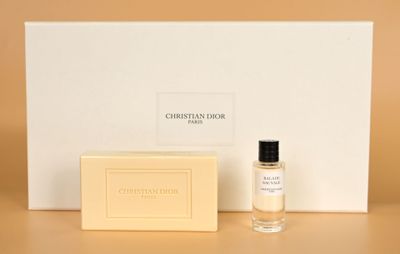 un flacon de parfum posé à côté d'une boîte de savon sur une table