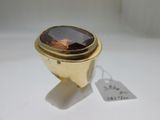 une image représentant une bague en or sertie d'une pierre brune