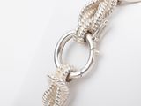 silver bracelet with a knot and a clasp on a white background