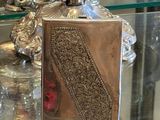 une table en verre sur laquelle se trouvent un vase en argent et un miroir