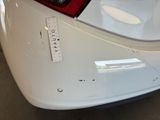 the rear end of a white car with a sticker on it ' s bumper