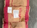 deux sacs de ciment sont posés sur une palette dans un entrepôt