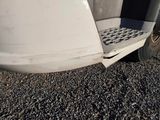 a close up of a white truck with a flat tire