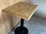 the table is made of wood and has a black metal base