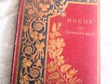un livre rouge et doré posé sur une nappe blanche