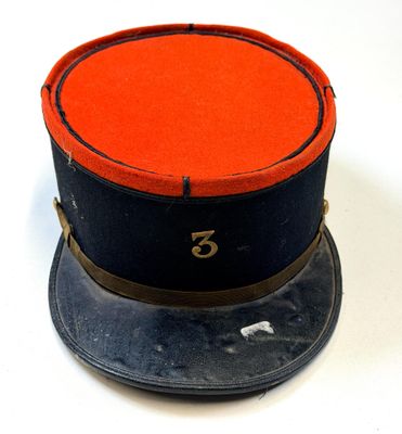 un chapeau sur lequel est posé un haut-de-forme rouge et noir
