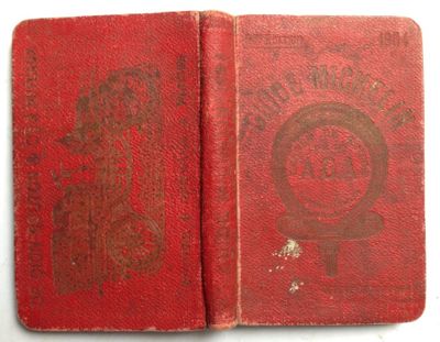 an old book with a red cover sitting on top of a table