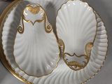 two white plates with gold trims and a gold rim