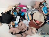 a pile of bags and purses on a white surface