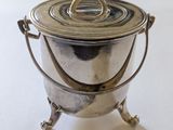 une casserole en argent avec une poignée, posée sur une table blanche