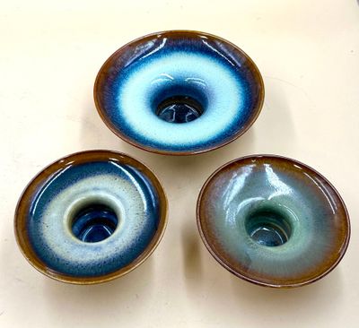 three blue and white bowls sitting on top of a white table
