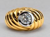 a yellow gold ring with a diamond set in the center