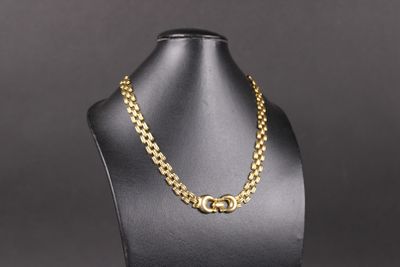 un collier à chaîne en or sur un mannequin, sur fond noir