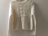 un pull blanc suspendu à un cintre contre un mur