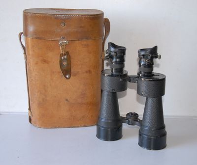 two binoculars sitting next to a bag on a table