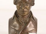 bronze bust of a man in a suit with a name tag on it