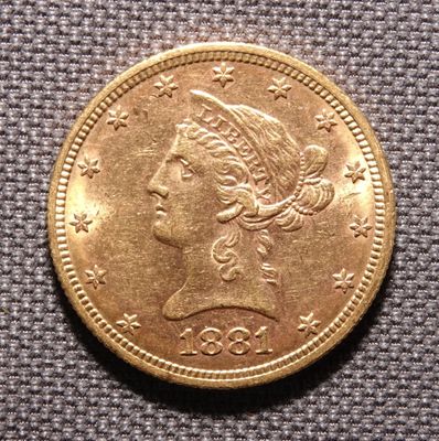Gros plan sur une pièce d'or ornée d'une tête de femme