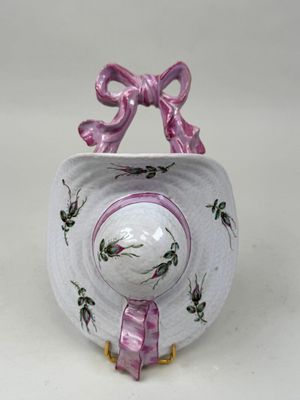 un petit bol blanc orné d'un nœud rose