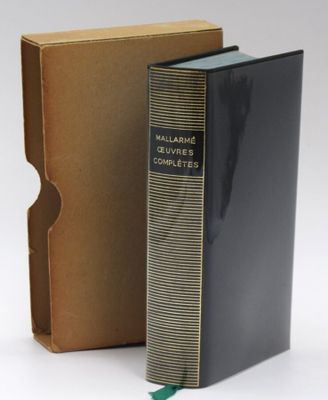 an old book in a cardboard box next to a cardboard box with a green ribbon