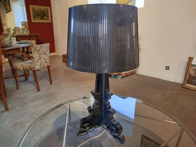 une table en verre sur laquelle est posée une lampe, dans un salon