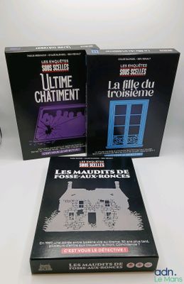trois livres posés sur une table blanche, avec une horloge et une lampe