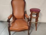 pair of leather chairs and stools in a room with a white wall