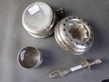 a silver tea pot and a tea strainer on a table