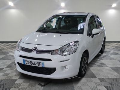 la petite voiture blanche est garée sur un carrelage à carreaux