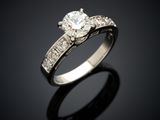a close up of a diamond ring on a black surface
