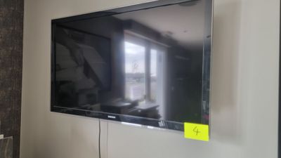 un téléviseur à écran plat fixé au mur d'une pièce